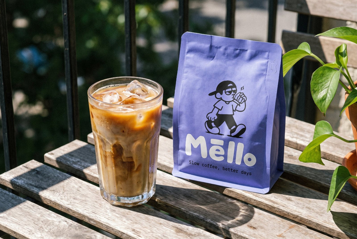 Iced coffee next to a Mello bag on a sunny balcony table